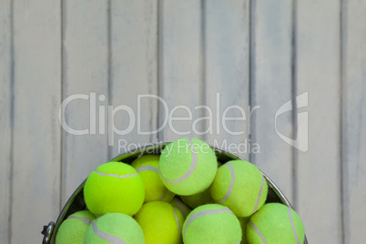 Directly above view of fluorescent yellow tennis balls in metallic bucket
