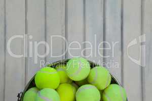 Directly above view of fluorescent yellow tennis balls in metallic bucket