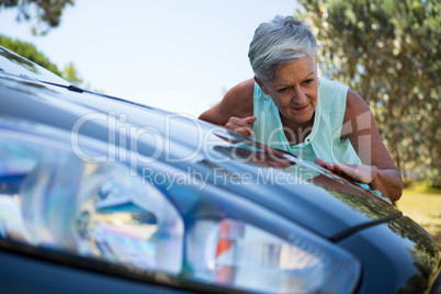 Senior woman checking her car