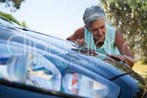 Senior woman checking her car