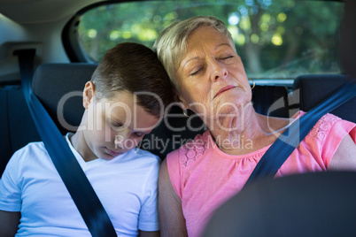 Grandmother and grandson relaxing in the back seat of car