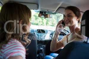 Woman talking on mobile phone in a car