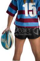 Mid section of female rugby player with rugby ball