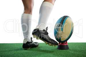 Low section of sportswoman kicking rugby ball
