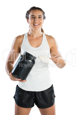 Portrait of smiling female athlete taking supplement powder