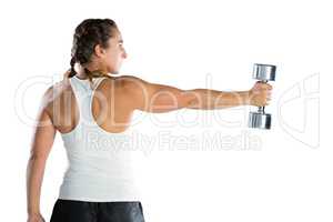 Rear view of female athlete exercising with dumbbell