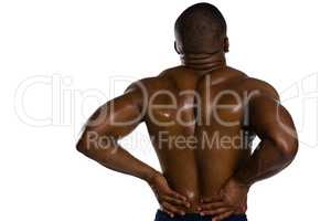 Rear view of shirtless sportsman suffering from back pain