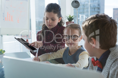 Kids as business executives discussion over digital tablet