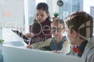 Kids as business executives discussion over digital tablet