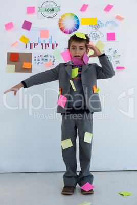 Boy as business executive with sticky notes on his body