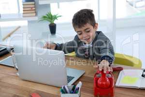 Boy as business executive using phone