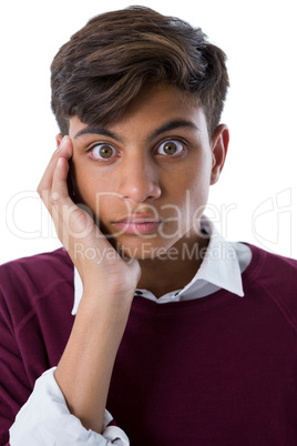 Shocked teenage boy standing against white background