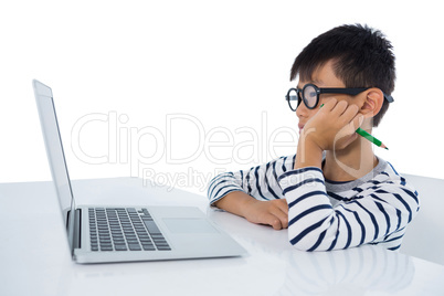 Boy sitting with laptop against white background