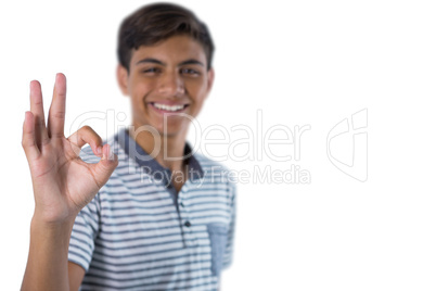 Smiling teenage boy gesturing okay hand sign
