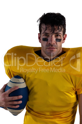 Portrait of American football player holding ball