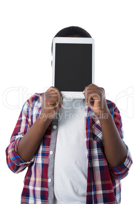 Boy hiding his face behind digital tablet