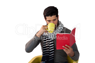 Man reading book while having coffee