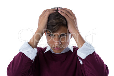 Upset teenage boy standing against white background