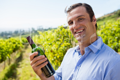Portrait of smiling vintner examining wine