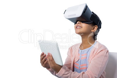 Girl holding digital tablet while using virtual reality glasses
