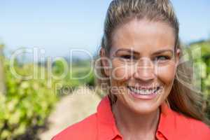 Portrait of smiling woman standing in vineyard