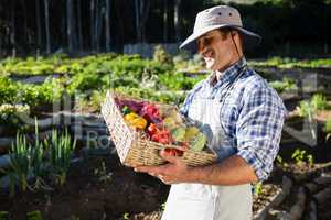 Happy man holding a basket of fresh vegetables