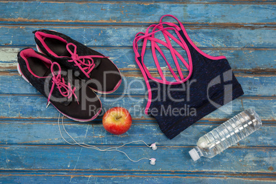 Overhead view of womenswear with apple and bottle by headphones