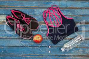Overhead view of womenswear with apple and bottle by headphones