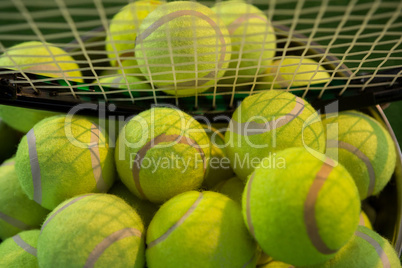 Racket on tennis balls in bucket