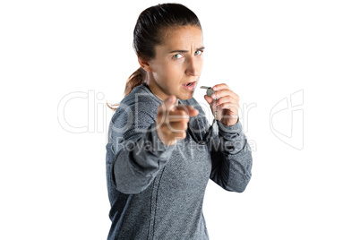Portrait of female coach gesturing while holding whistle