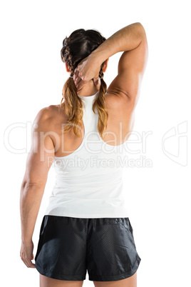 Rear view of sportswoman massaging neck