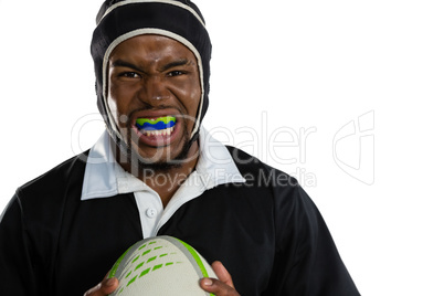 Portrait of male rugby player wearing mouthguard white holding rugby ball