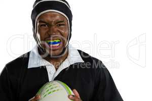 Portrait of male rugby player wearing mouthguard white holding rugby ball