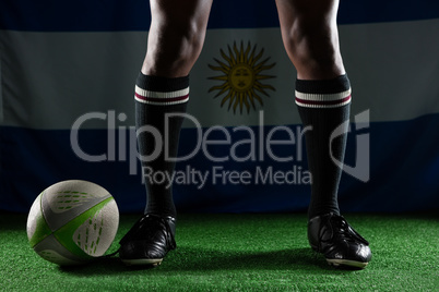 Low section of rugby player standing against Argentinian Flag
