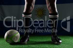 Low section of rugby player standing against Argentinian Flag