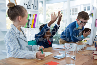 Boy as business executive laughing while looking at digital tablet