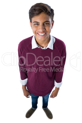 Happy teenage boy standing against white background