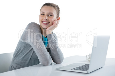 Smiling teenage girl sitting against white background