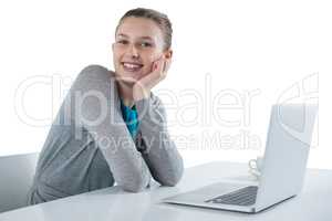Smiling teenage girl sitting against white background