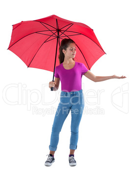 Teenage girl standing under a red umbrella