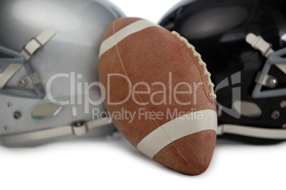 Close up of brown American football with sports helmet