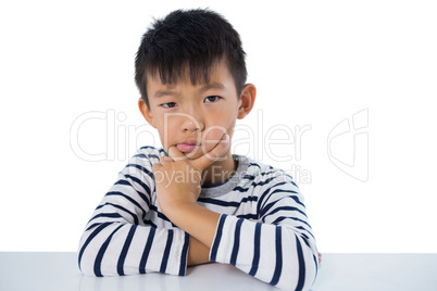 Sad boy sitting against white background Sad boy sitting against white background