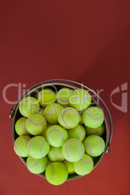 Overhead view of fluorescent yellow tennis balls in bucket