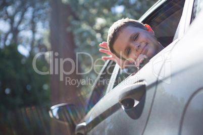 Teenage boy looking from open car window