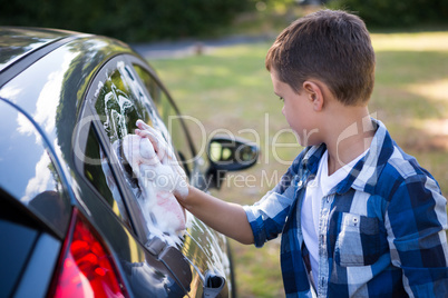 Teenage boy washing a car