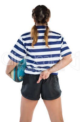 Rear view of female rugby player with fingers crossed