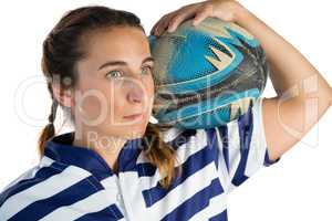 Close up of female player holding rugby ball while looking away