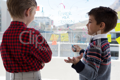 Kids as business executives discussing over whiteboard