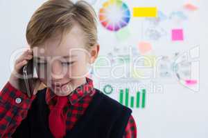 Boy as business executive using talking on mobile phone