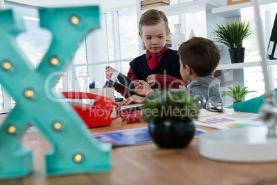 Kids as business executives discussing over digital tablet
